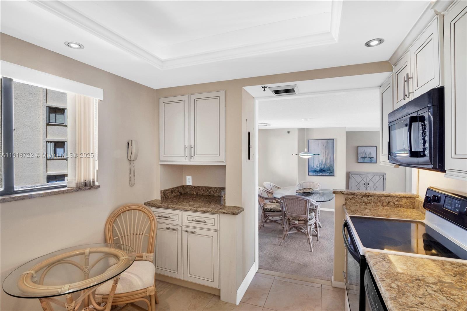 200 Ocean Trail Way, Unit 609 Jupiter, FL 33477 - Photo 10 of 27 a kitchen with a stove top oven a sink dishwasher and white cabinets with wooden floor
