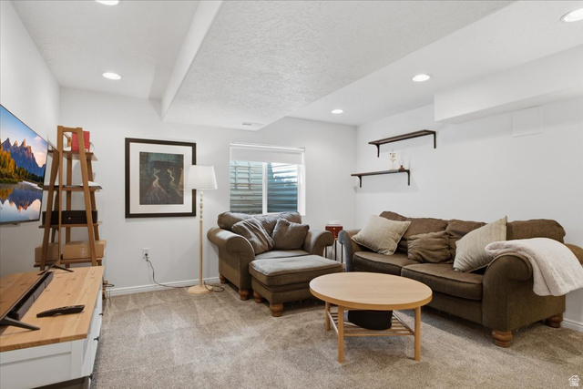 12151 Andrew View Circle Draper, UT 84020 - Photo 25 of 31 Open living area featuring recessed ceiling lighting, a window with blinds, wall-mounted shelving, and carpet flooring