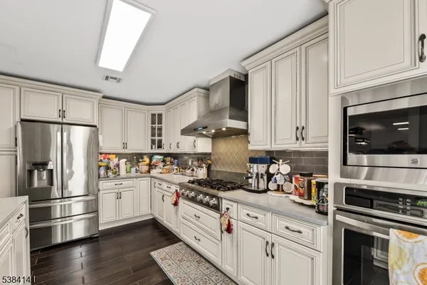 a kitchen with stainless steel appliances a refrigerator stove and microwave