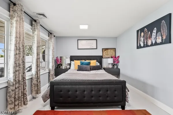 a bedroom with a bed window and wall painting