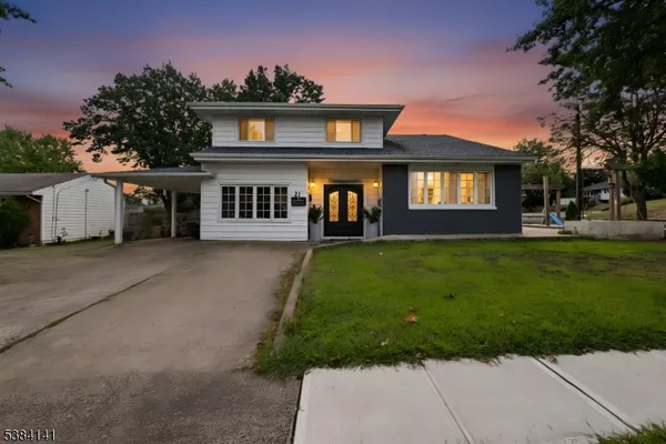 a front view of a house with a yard and trees