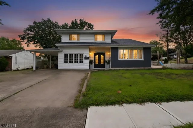 a front view of a house with a yard and trees