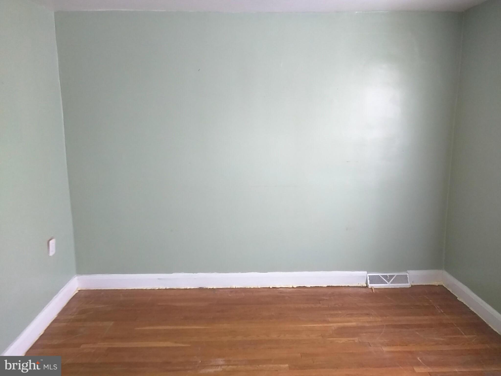 6939 Glenheights Road Baltimore, MD 21215 - Photo 11 of 21 a view of an empty room with wooden floor and a window
