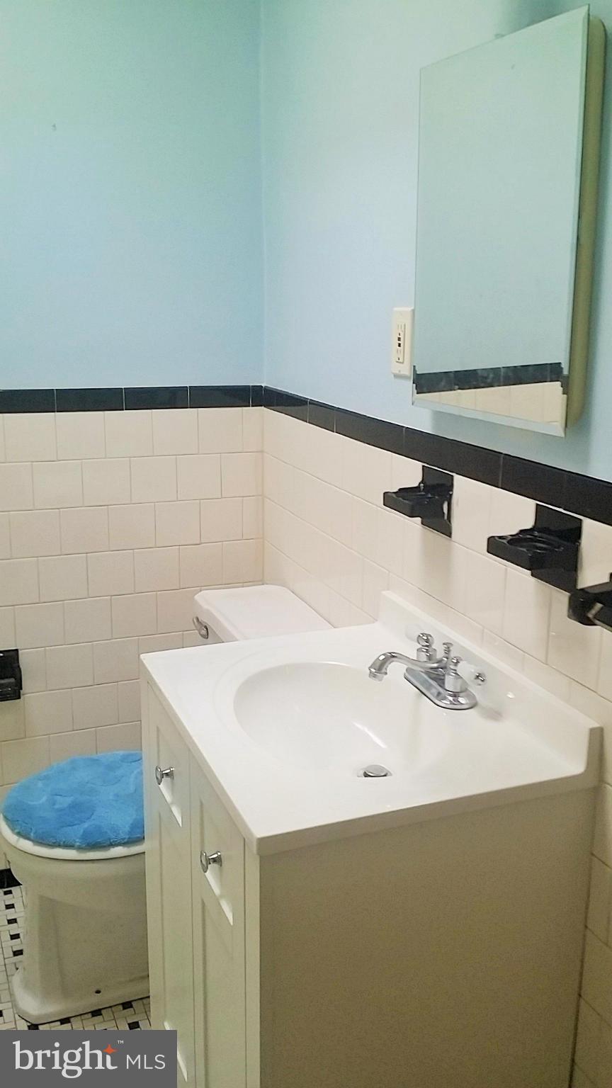 6939 Glenheights Road Baltimore, MD 21215 - Photo 15 of 21 a bathroom with a sink toilet and mirror