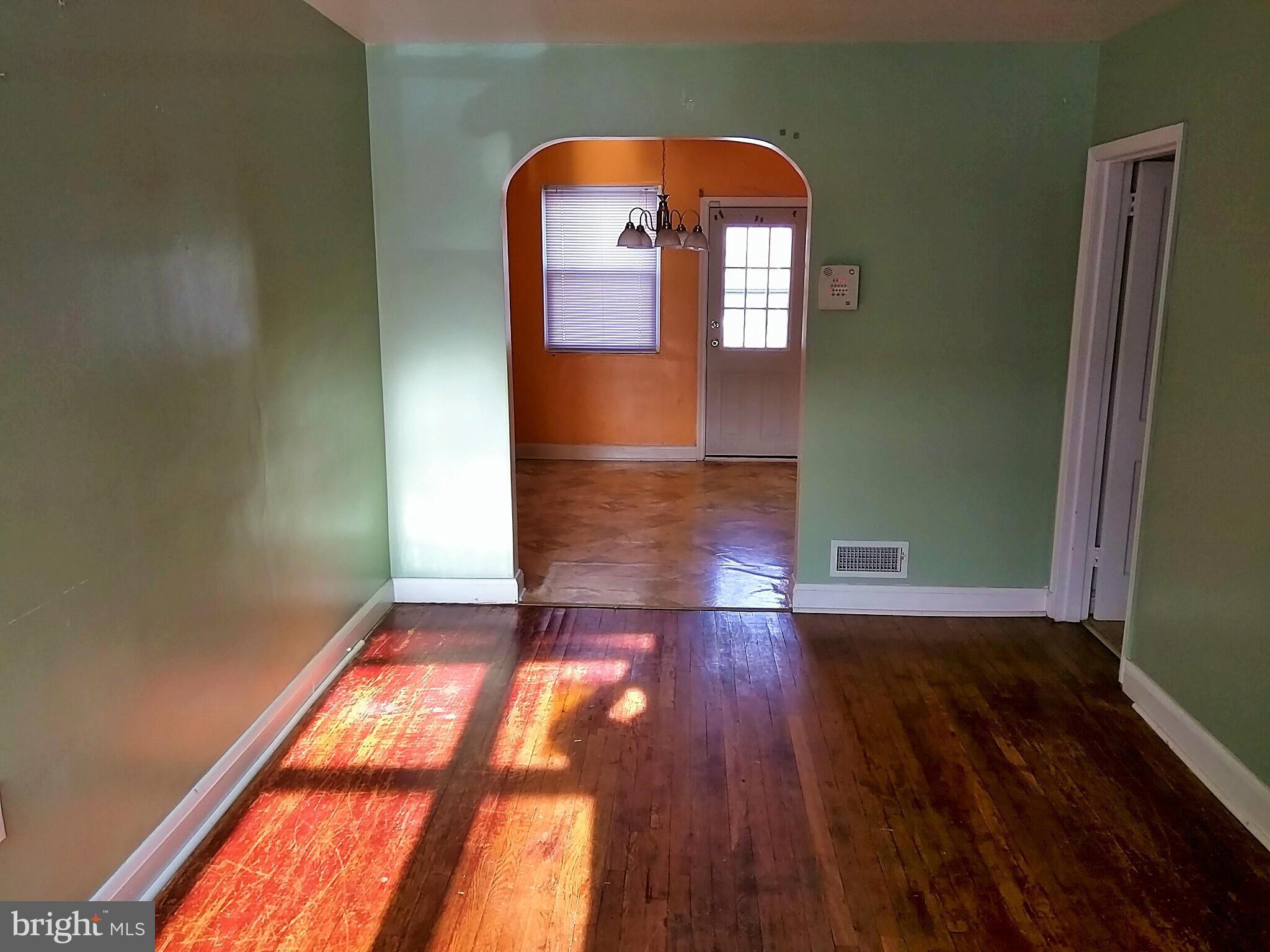 6939 Glenheights Road Baltimore, MD 21215 - Photo 3 of 21 an empty room with wooden floor and windows