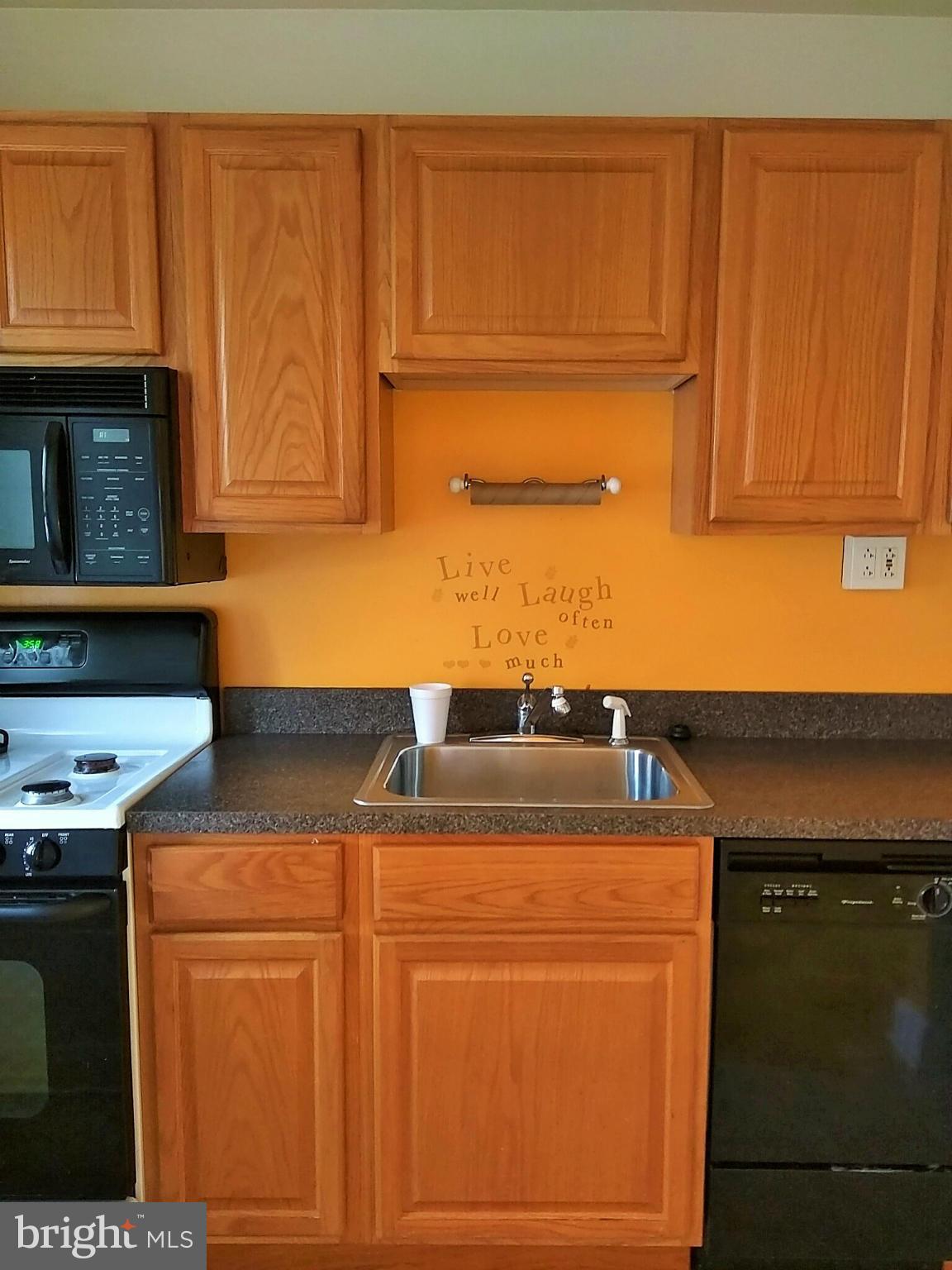 6939 Glenheights Road Baltimore, MD 21215 - Photo 8 of 21 a kitchen with granite countertop cabinets and black appliances