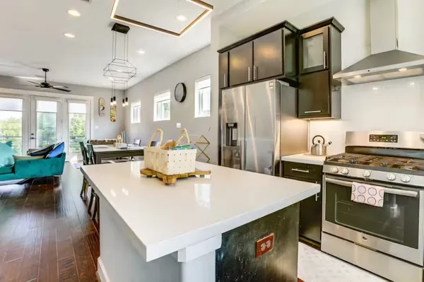 a kitchen with stainless steel appliances granite countertop a sink a stove and a refrigerator
