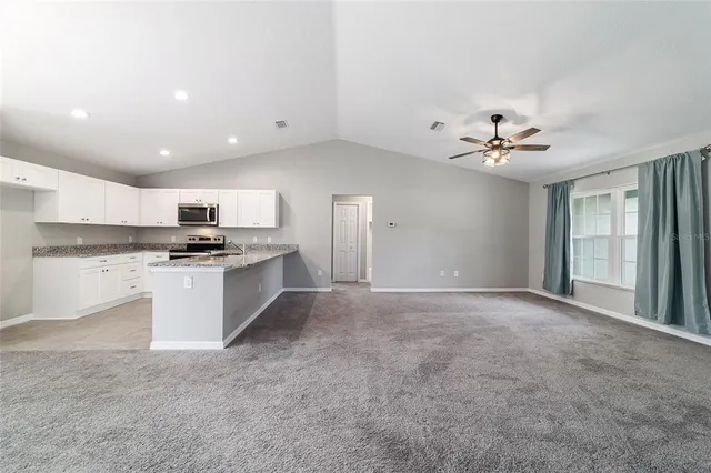 a view of kitchen with sink cabinets and window