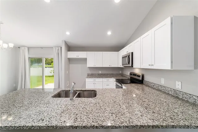 a kitchen with stainless steel appliances granite countertop a sink stove and cabinets