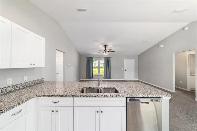 a kitchen with granite countertop a sink and cabinets