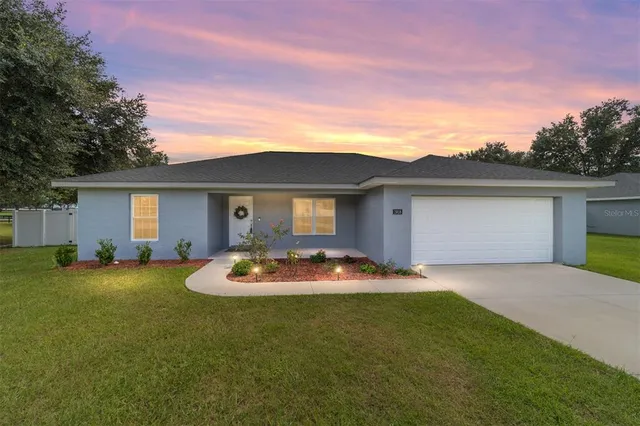 a front view of house with yard and garage
