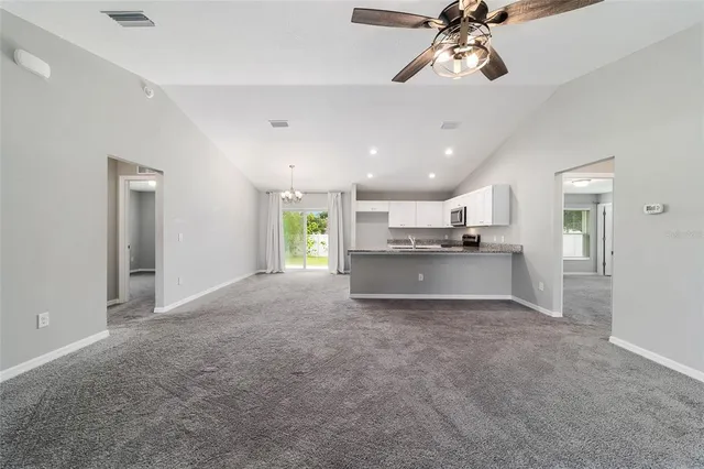 a view of a kitchen with a sink and chandelier fan