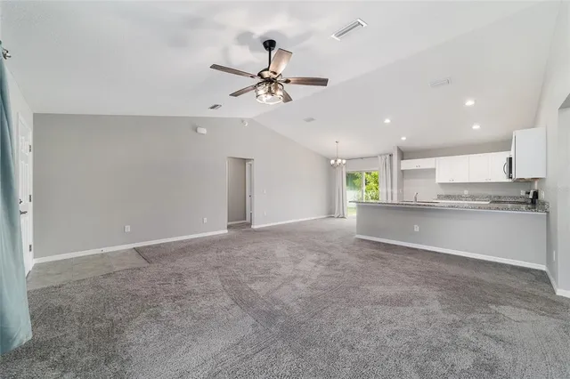a view of an empty room and kitchen view