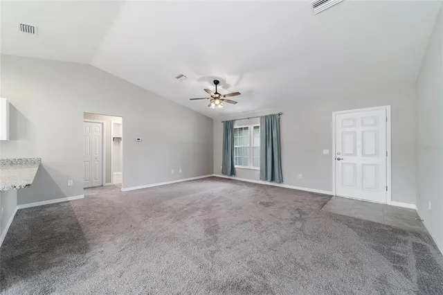 a view of a livingroom with a ceiling fan and window