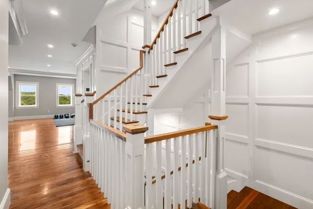 a view of staircase with wooden floor and white walls