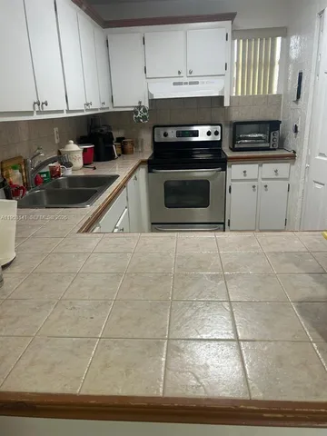 a kitchen with stainless steel appliances a stove a sink and a microwave