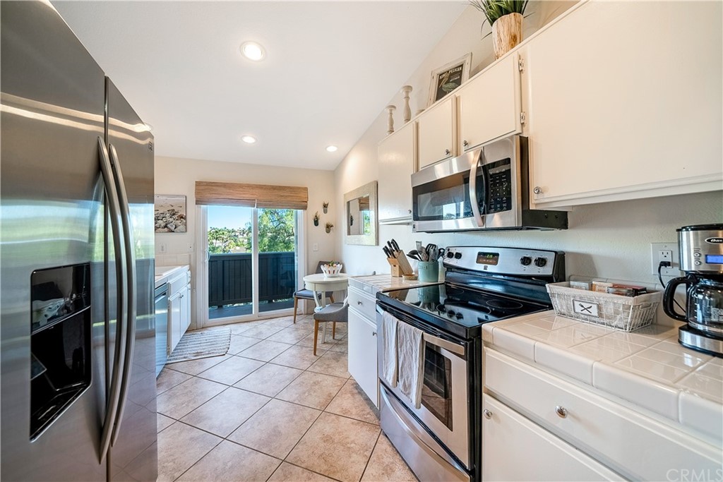 26 Corniche Drive, Unit F Dana Point, CA 92629 - Photo 13 of 46 a kitchen with stainless steel appliances a stove a refrigerator and a sink