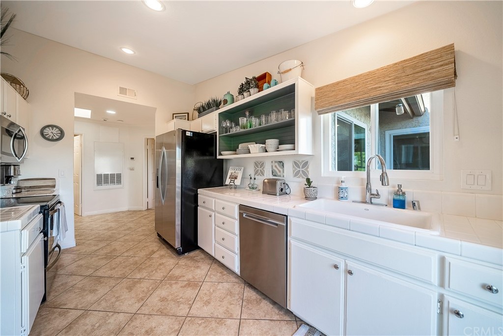 26 Corniche Drive, Unit F Dana Point, CA 92629 - Photo 15 of 46 a kitchen with a sink and refrigerator