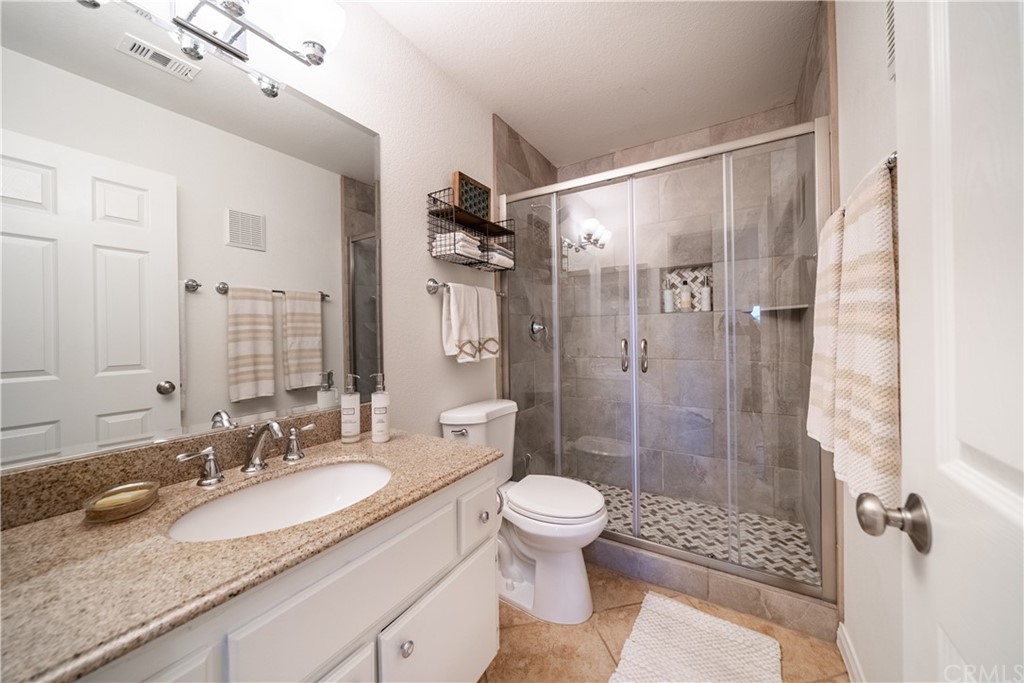 26 Corniche Drive, Unit F Dana Point, CA 92629 - Photo 32 of 46 a bathroom with a granite countertop shower sink vanity mirror and toilet