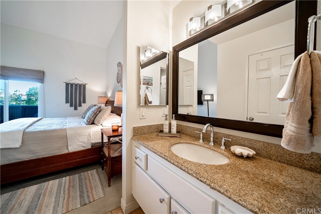 26 Corniche Drive, Unit F Dana Point, CA 92629 - Photo 33 of 46 a bathroom with a granite countertop sink and a mirror