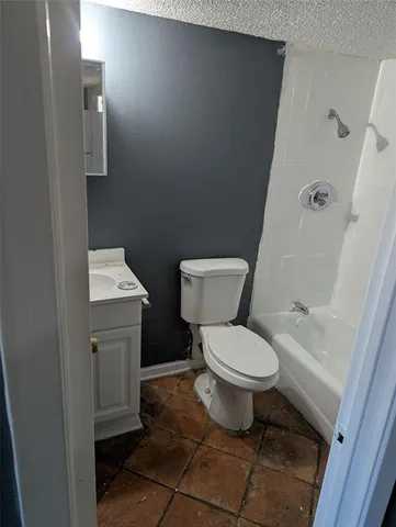 a white toilet sitting next to a bathroom sink and vanity