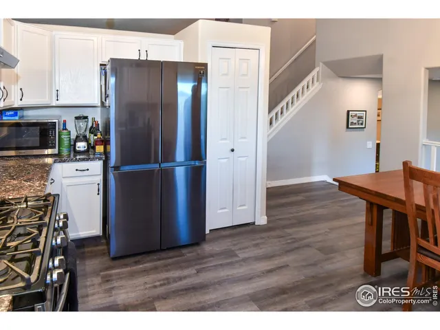 a kitchen with stainless steel appliances wooden floor and chair