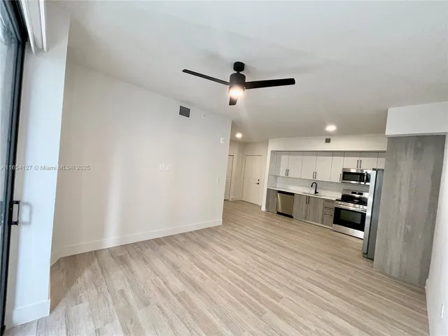 a view of a kitchen with wooden floor and a sink