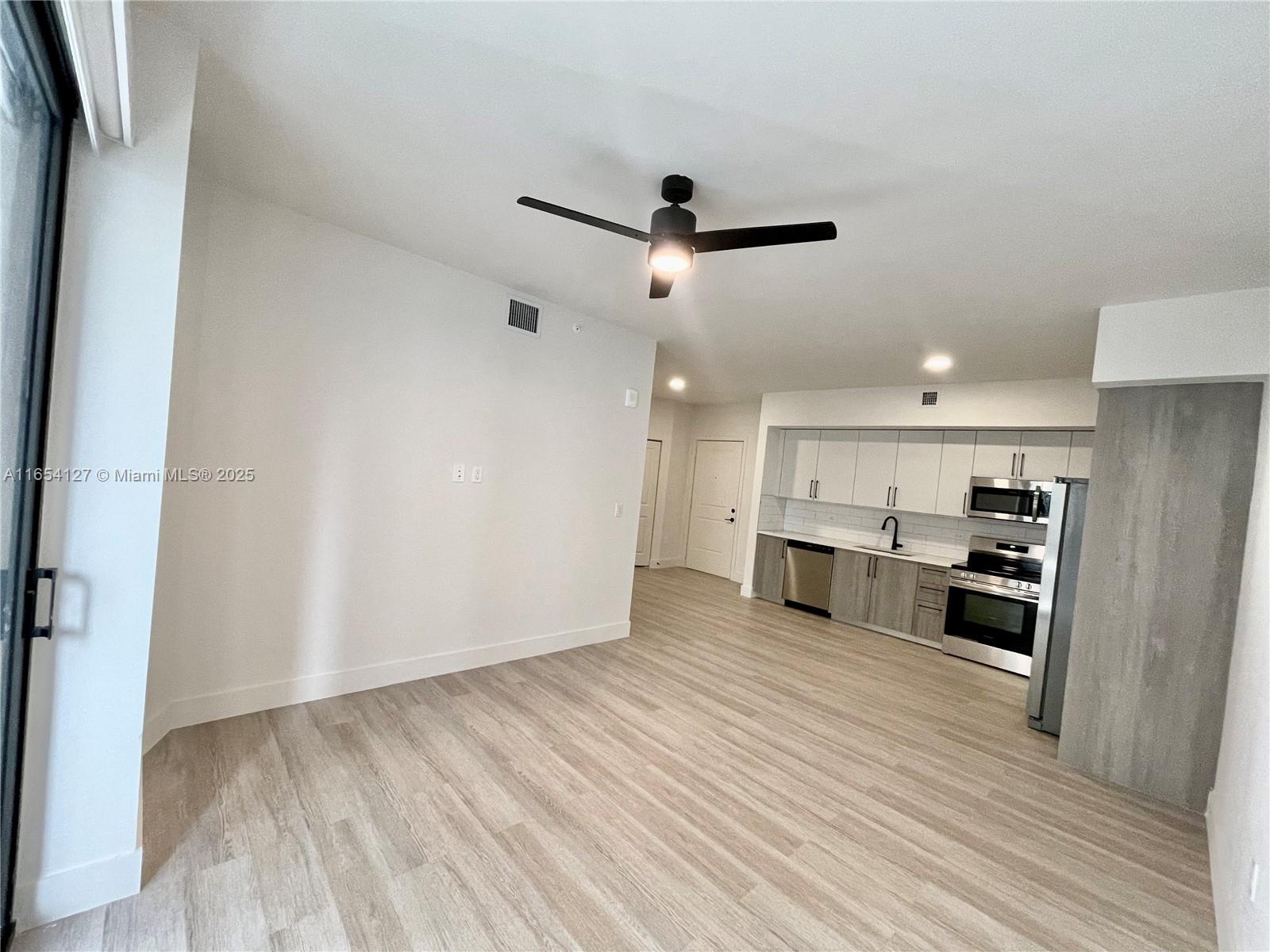 a view of a kitchen with wooden floor and a sink