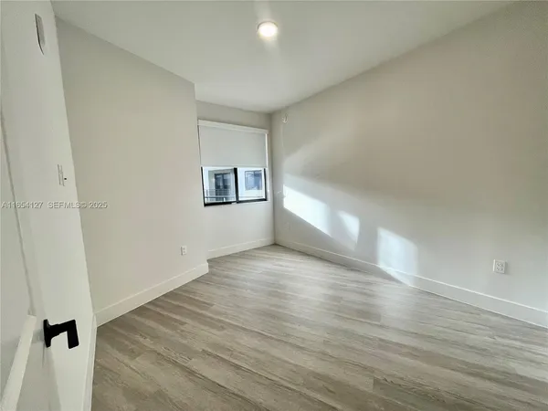 a view of a hallway with wooden floor and closet