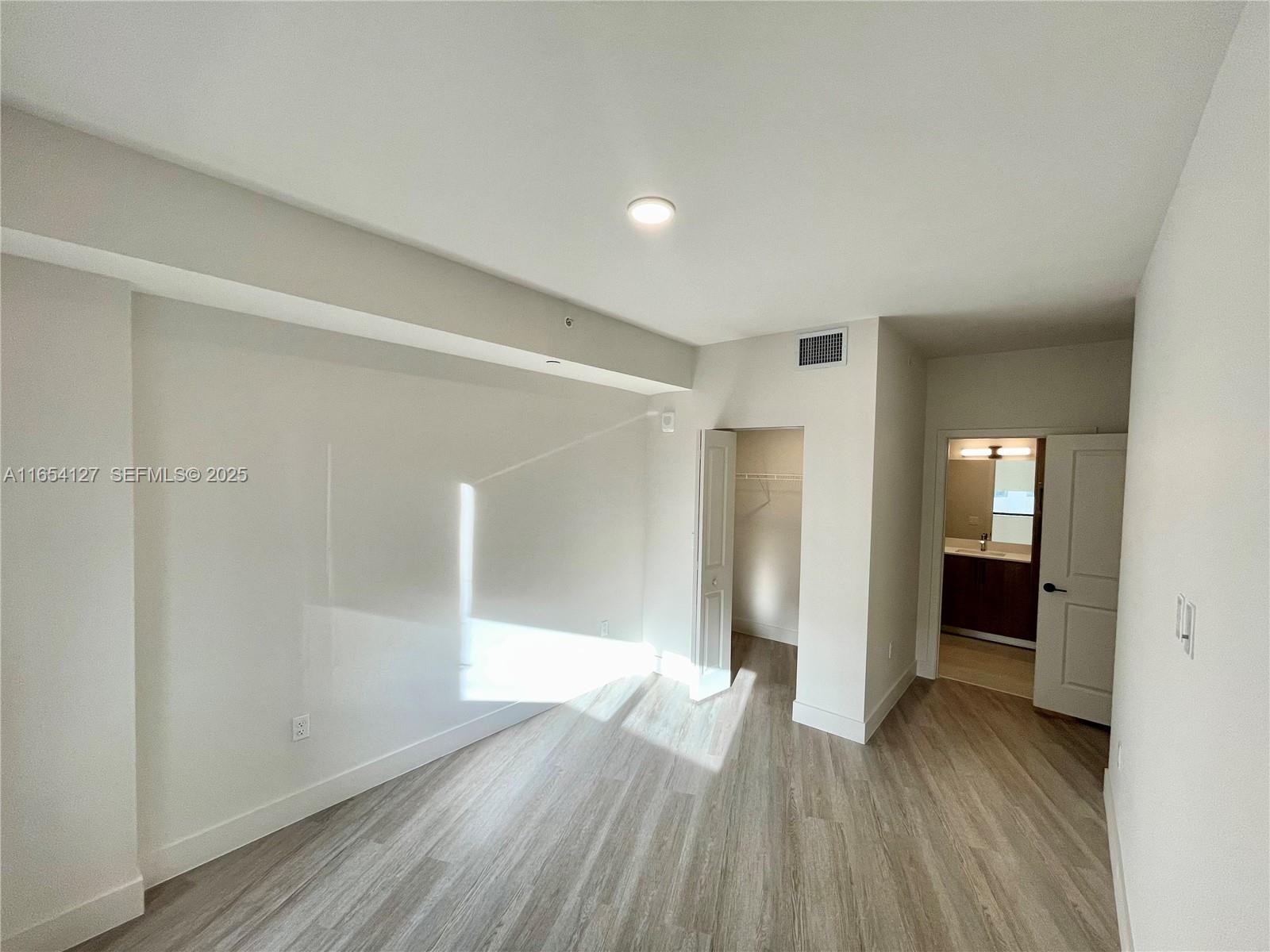 18412 Homestead Avenue, Unit 727 Miami, FL 33157 - Photo 8 of 24 a view of a hallway with wooden floor and closet