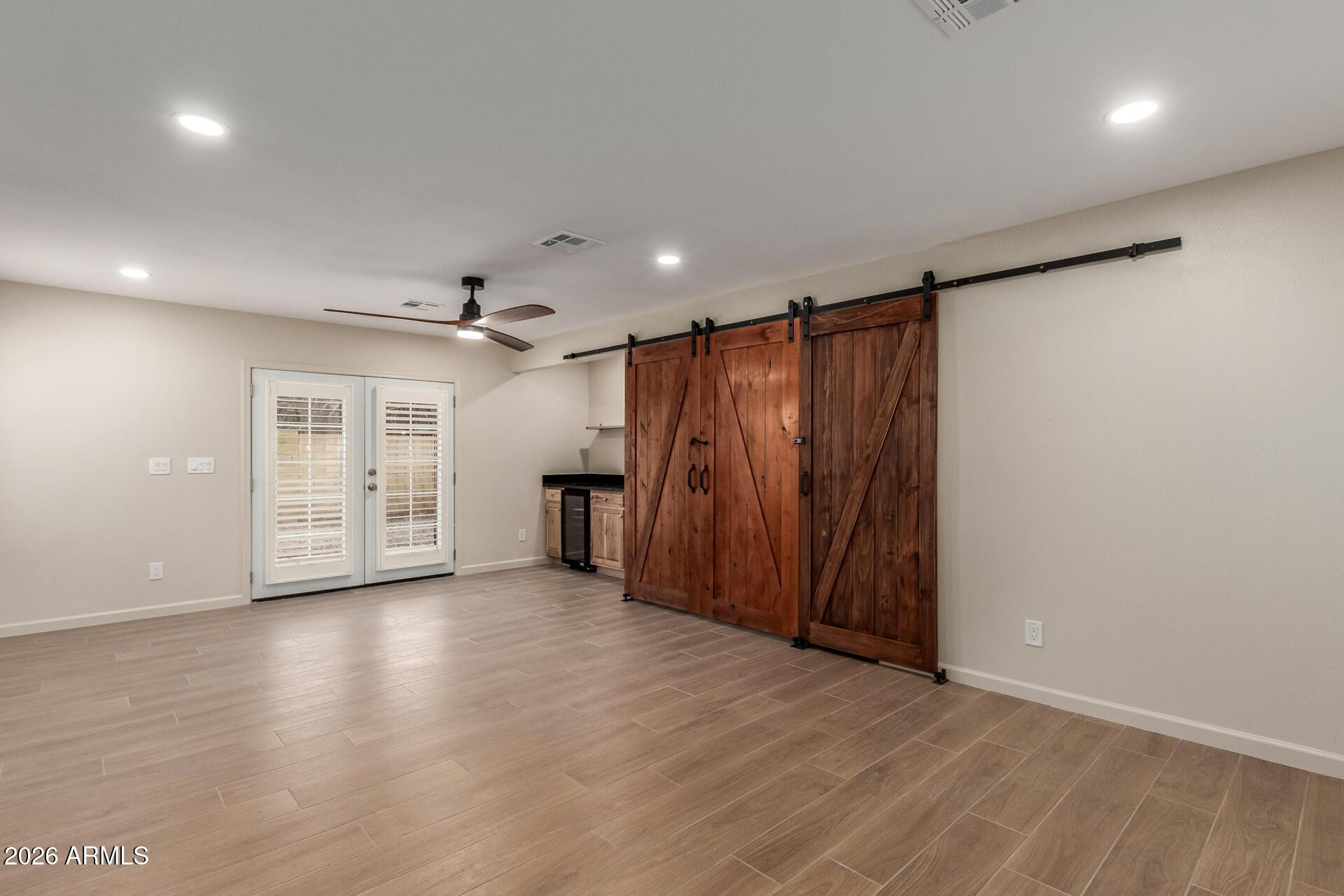 1628 East Del Rio Drive Tempe, AZ 85282 - Photo 11 of 32 an empty room with wooden floor and a kitchen