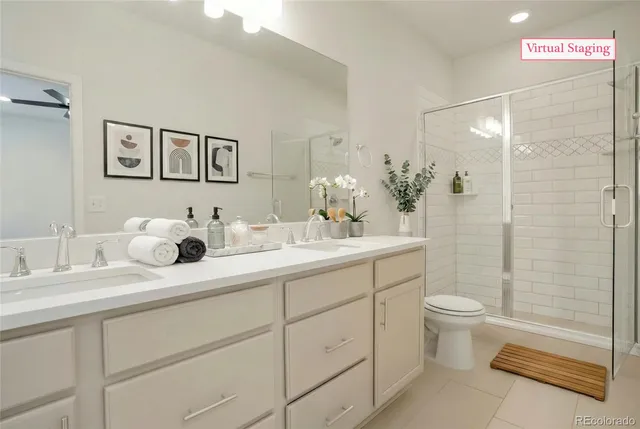 a bathroom with a double vanity sink toilet and shower