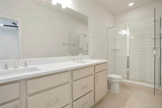 a bathroom with a double vanity sink toilet and shower