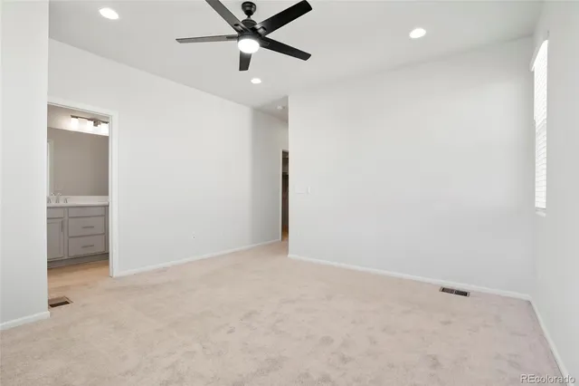 an empty room with closet and fan