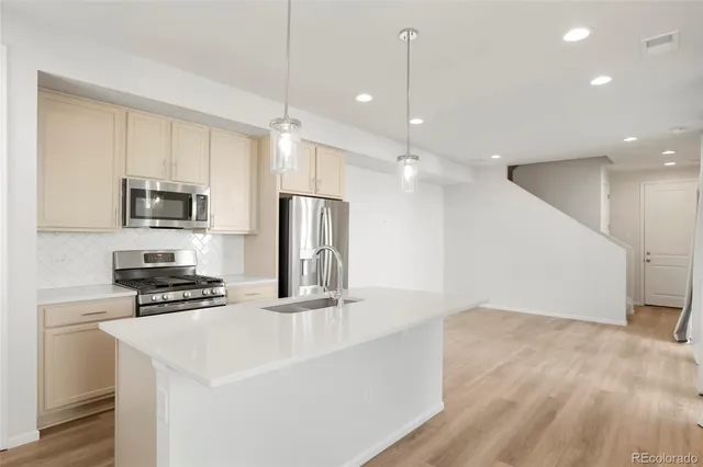 a kitchen with kitchen island a sink stainless steel appliances and cabinets