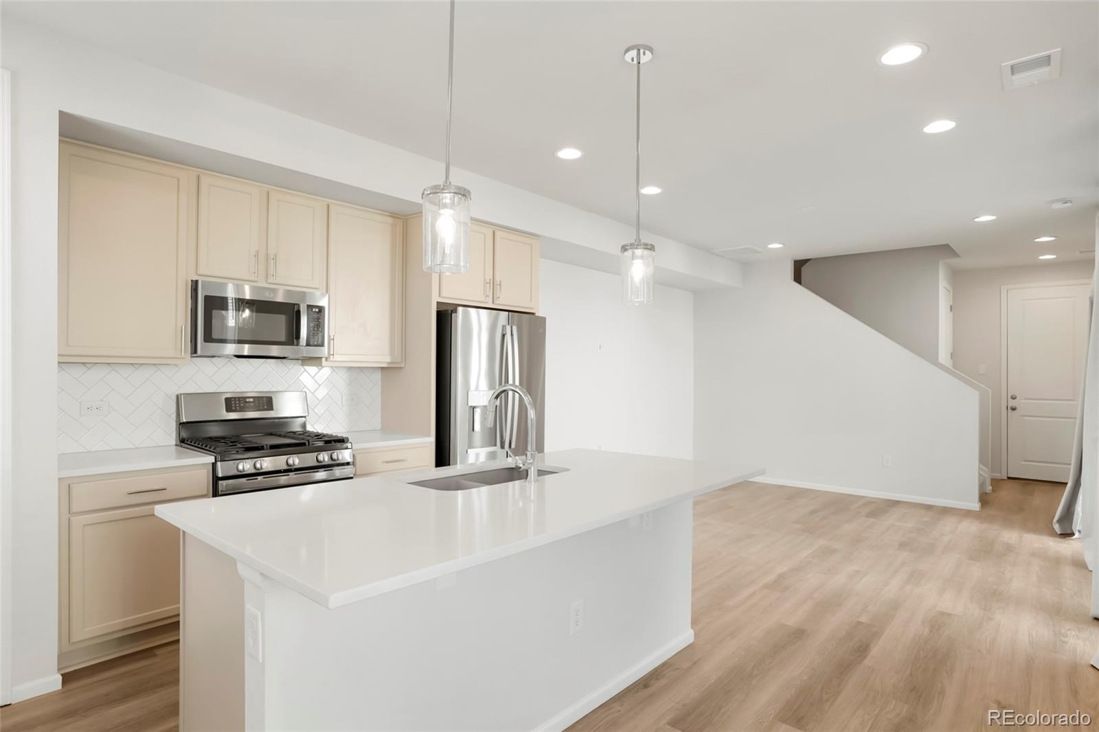 1675 South Andes Way Aurora, CO 80017 - Photo 7 of 32 a kitchen with kitchen island a sink stainless steel appliances and cabinets