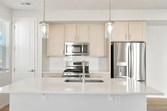 a kitchen with kitchen island a counter top space appliances and cabinets