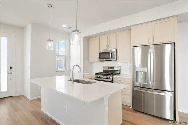 a kitchen with stainless steel appliances a refrigerator stove microwave and sink