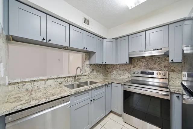 a kitchen with granite countertop white cabinets and a sink