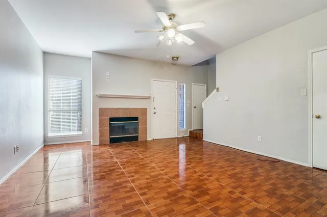 wooden floor fireplace and windows in an empty room