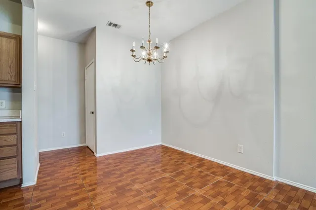 a view of a room with wooden floor and chandelier