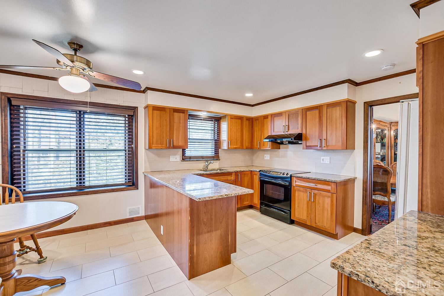 41 Clive Hills Road Edison, NJ 08820 - Photo 15 of 39 a kitchen with stainless steel appliances granite countertop a stove top oven a sink a dining table and chairs