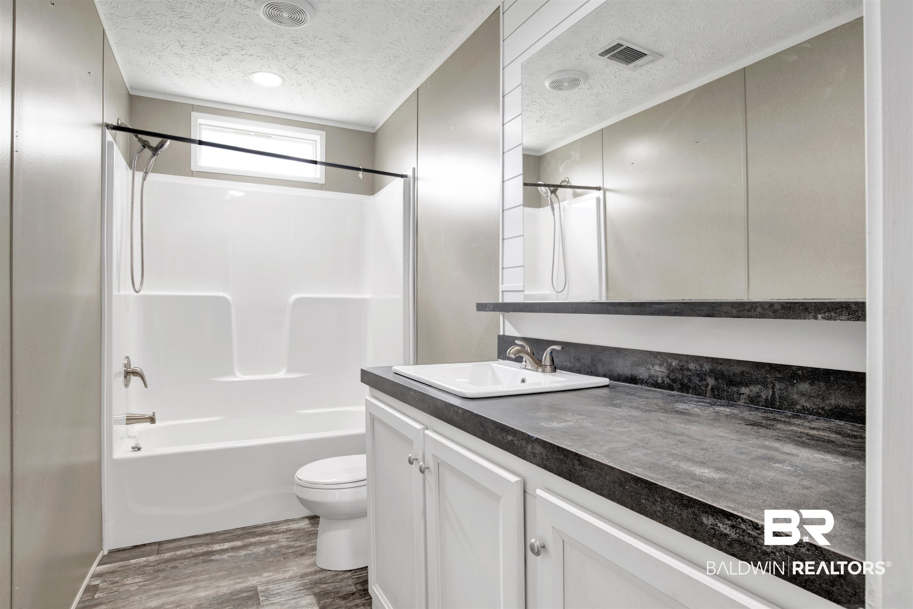 16778 County Road 87 Elberta, AL 36530 - Photo 28 of 32 Full bathroom with a textured ceiling, toilet, vanity, shower / bathtub combination, and hardwood / wood-style flooring