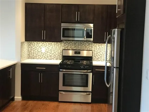 a kitchen with stainless steel appliances granite countertop a stove microwave and refrigerator