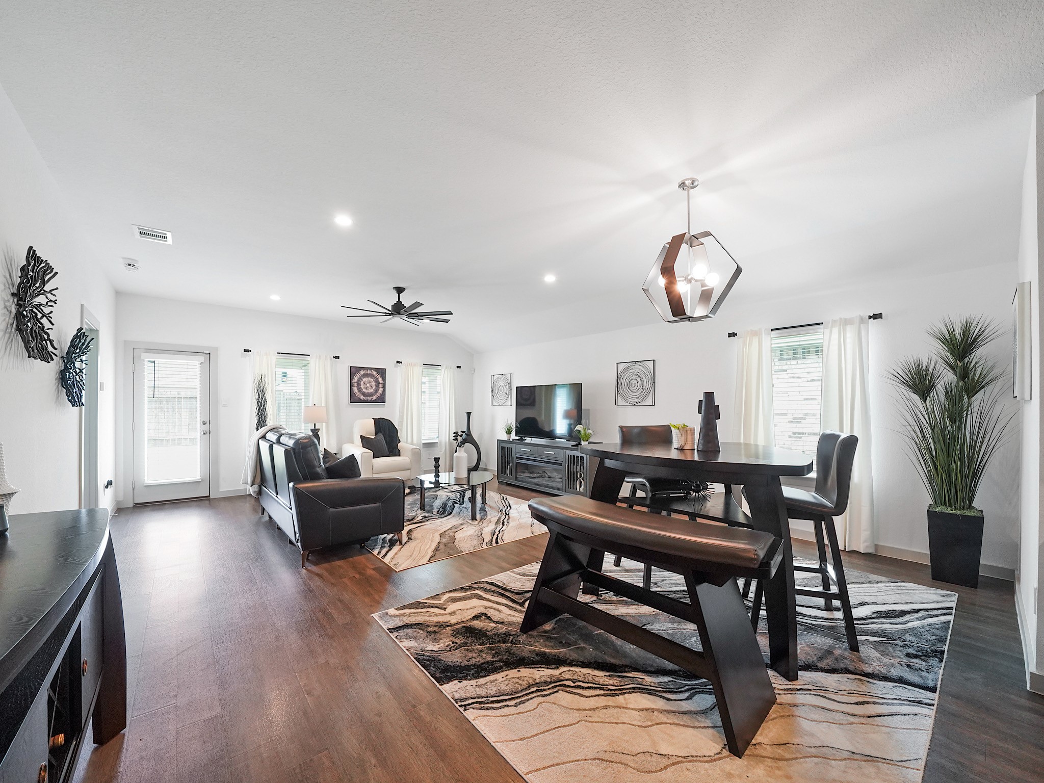 7823 Cattlewood Pass Rosharon, TX 77583 - Photo 6 of 17 Spacious, open-concept living and dining area. The room is well-lit with natural light from multiple windows, a stylish light fixture highlights the dining space, and a ceiling fan adds comfort.