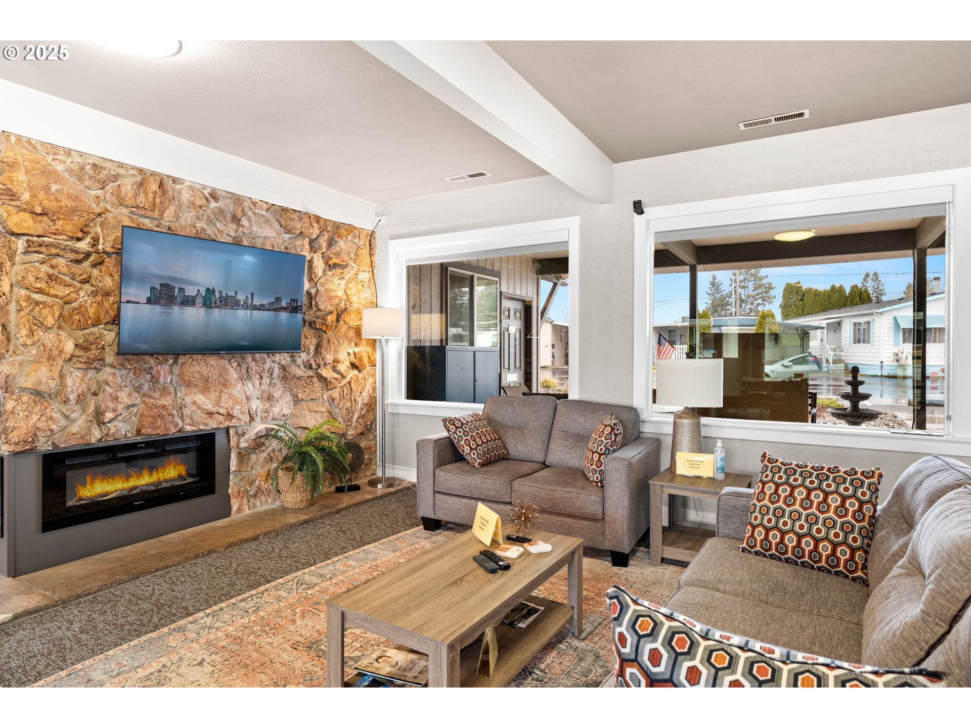 19605 River Road, Unit 88 Gladstone, OR 97027 - Photo 22 of 25 a living room with furniture a flat screen tv and a fireplace