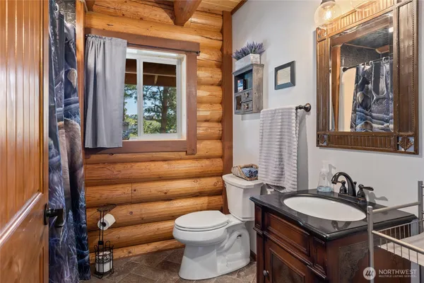 a bathroom with a granite countertop sink and a toilet