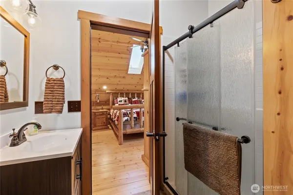 a en suite bathroom with a granite countertop sink a mirror and shower