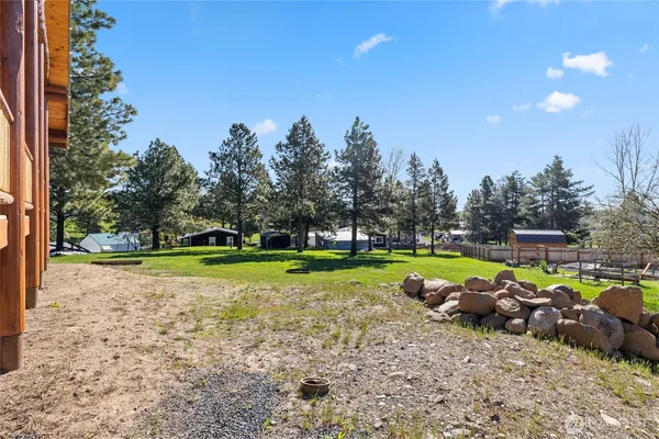 a view of swimming pool with lawn chairs and a yard