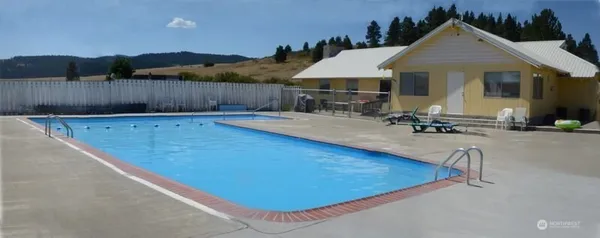 a view of a house with swimming pool and sitting area
